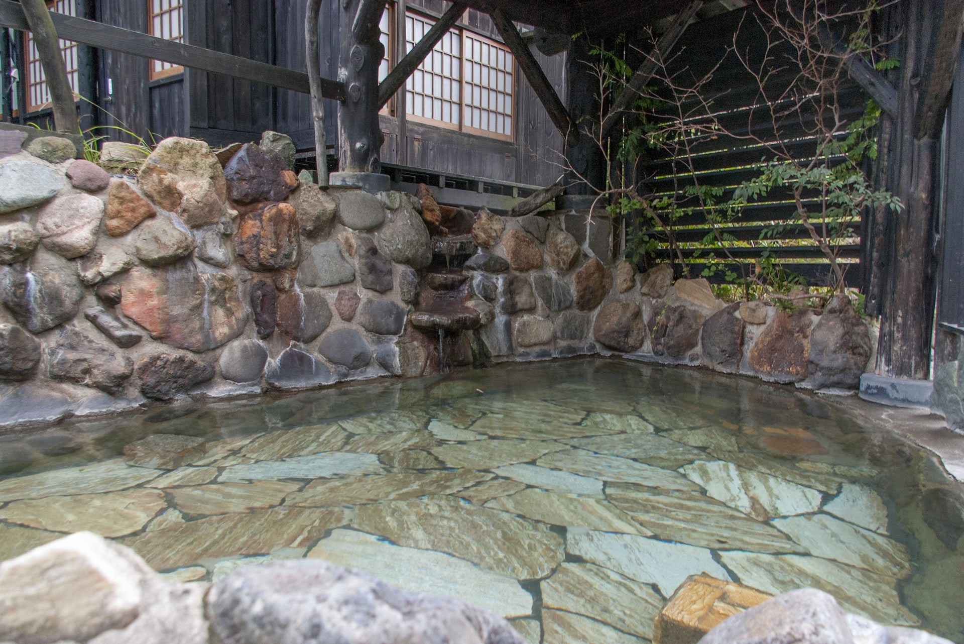 主人手作りの半屋根付きの露天風呂です。川のせせらぎ、鳥のさえずり、　そして、頬をなでる風を感じて心身の疲れをお癒しください。